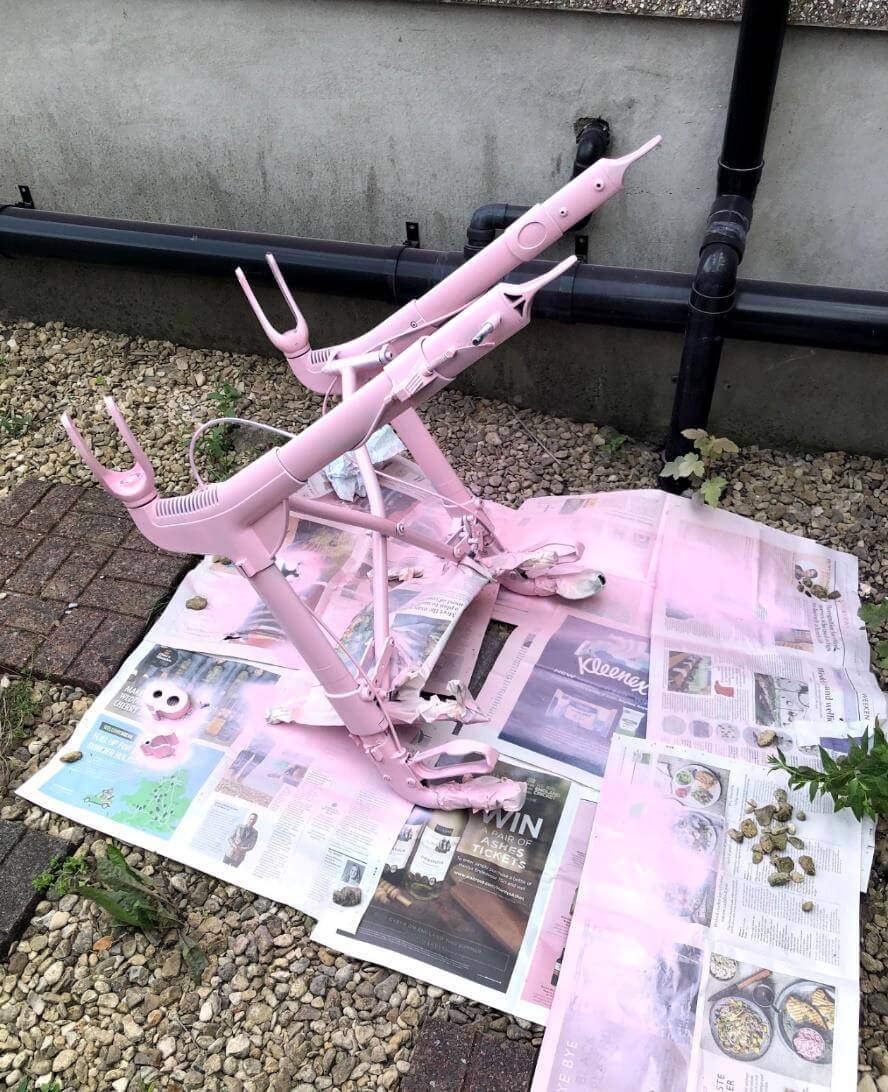 the walker is upside down and sprayed with bubble gujm pink spray