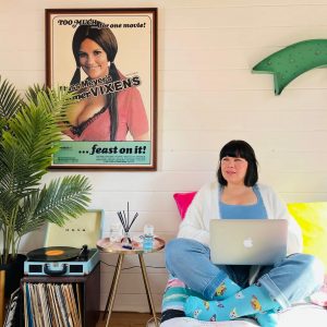 Nina is sat on her bed wearing our blue dog compression socks