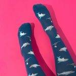 dark navy shark compression socks on a dark pink background