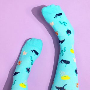 Turquoise compression socks with sea life pattern on lilac background